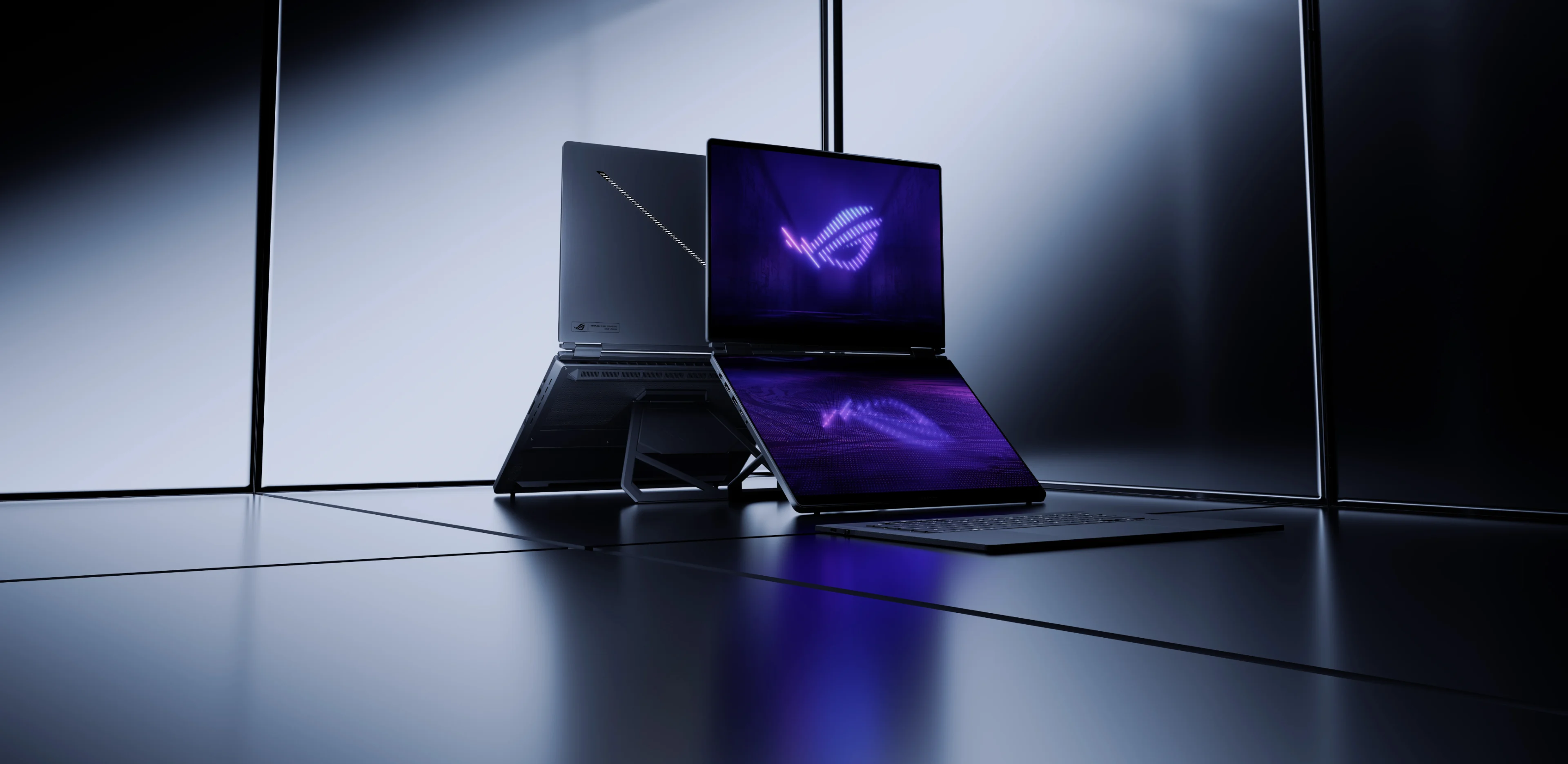 Escena oficial de ASUS ROG Zephyrus Duo 2026 con dos equipos de doble pantalla y reflejos violetas en una sala metálica.